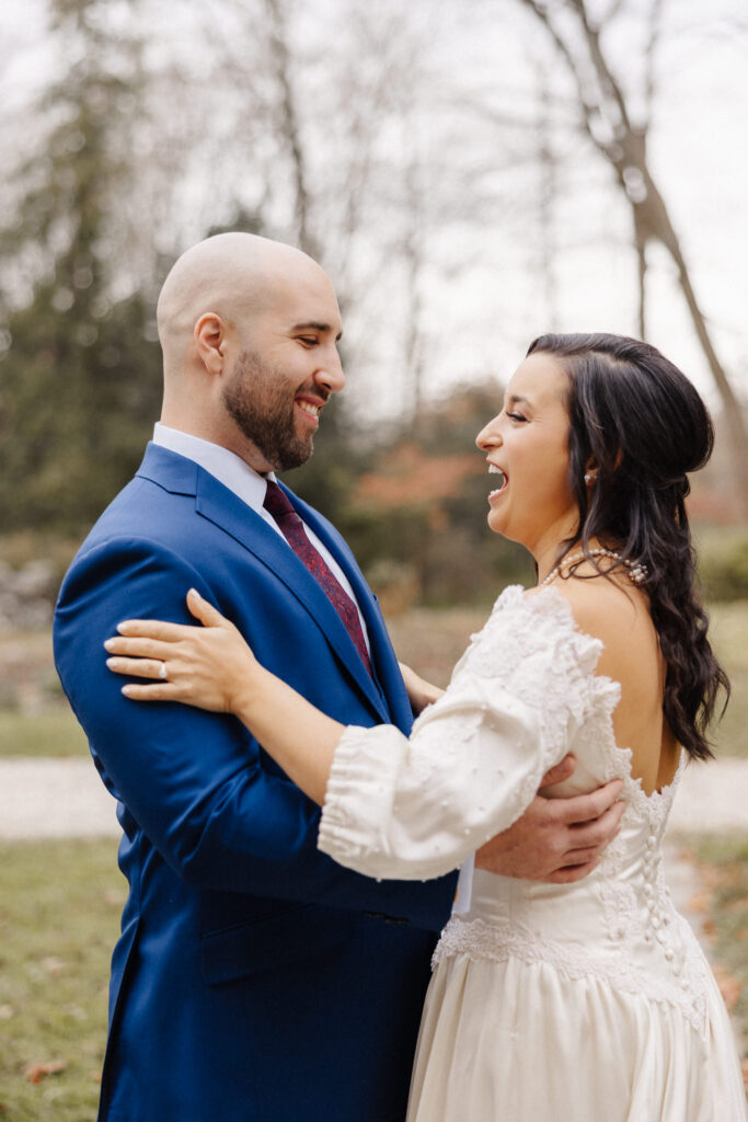 Couple laughing together outdoors on their wedding day, candid documentary portrait by Honey & Bloom Photography