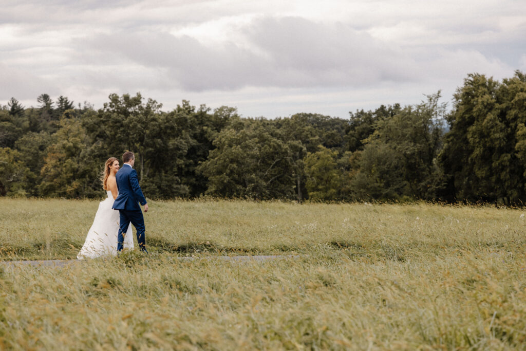 Couple holding each other in an open field during an outdoor elopement in Central New York, Honey and Bloom Photography.