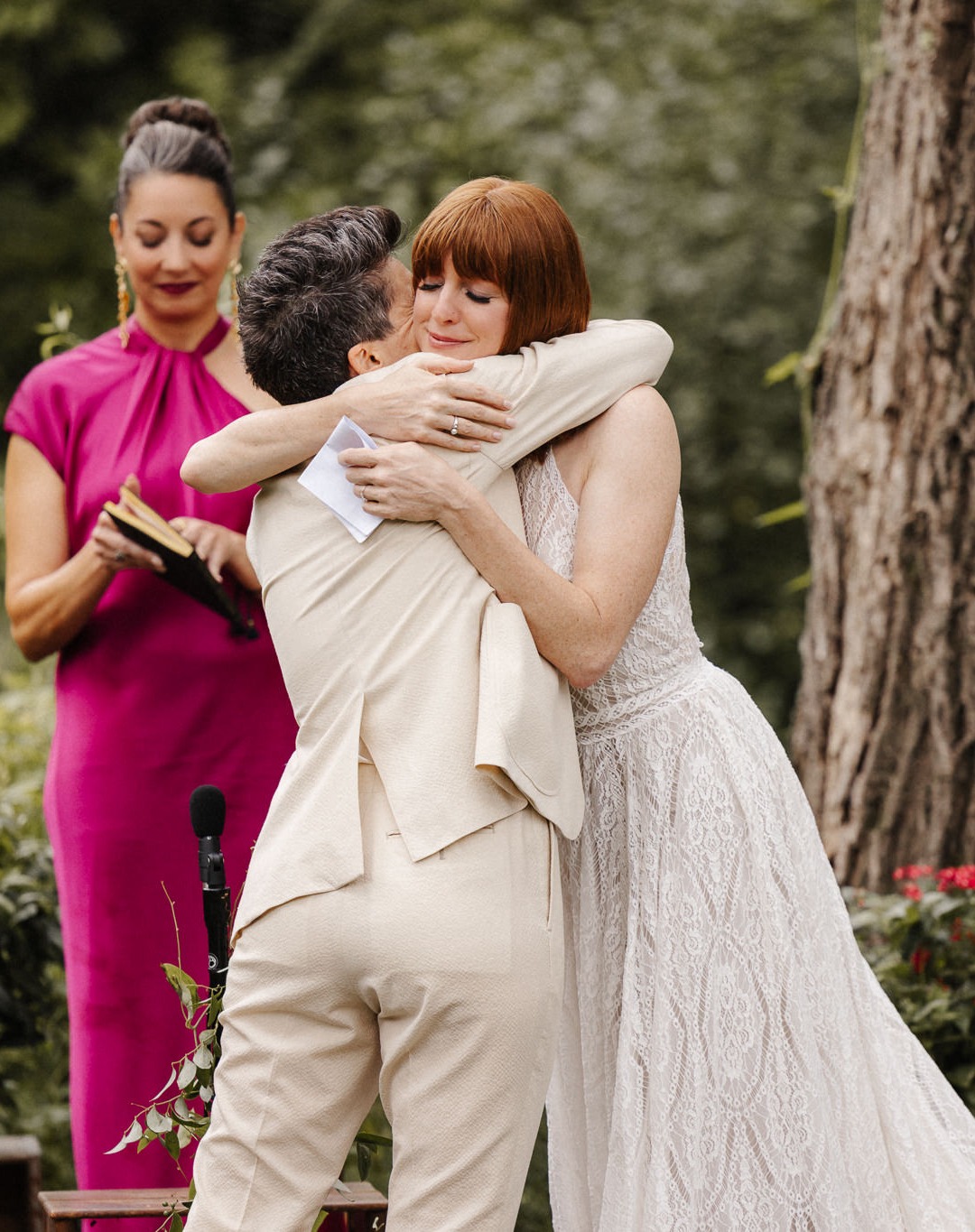 Two brides embracing during their outdoor wedding ceremony in Central New York.