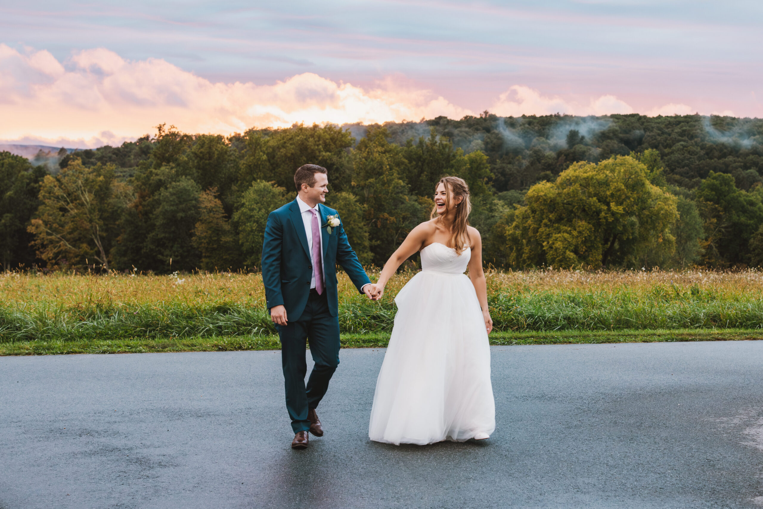 Bride and groom walking hand in hand at sunset after rain at their Central New York wedding, Honey and Bloom Photography
