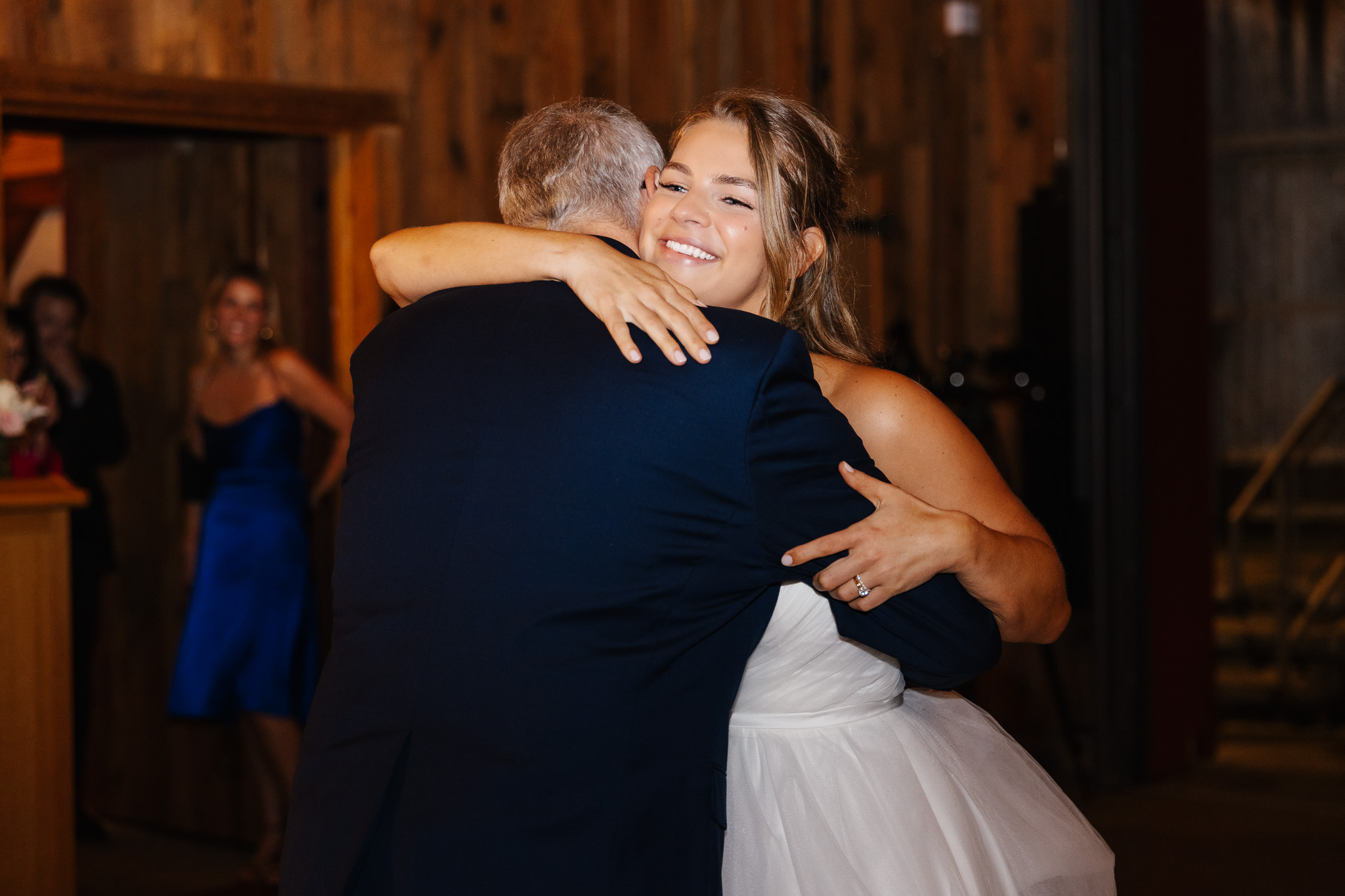 Bride smiling as she embraces a loved one during her Central New York wedding reception.