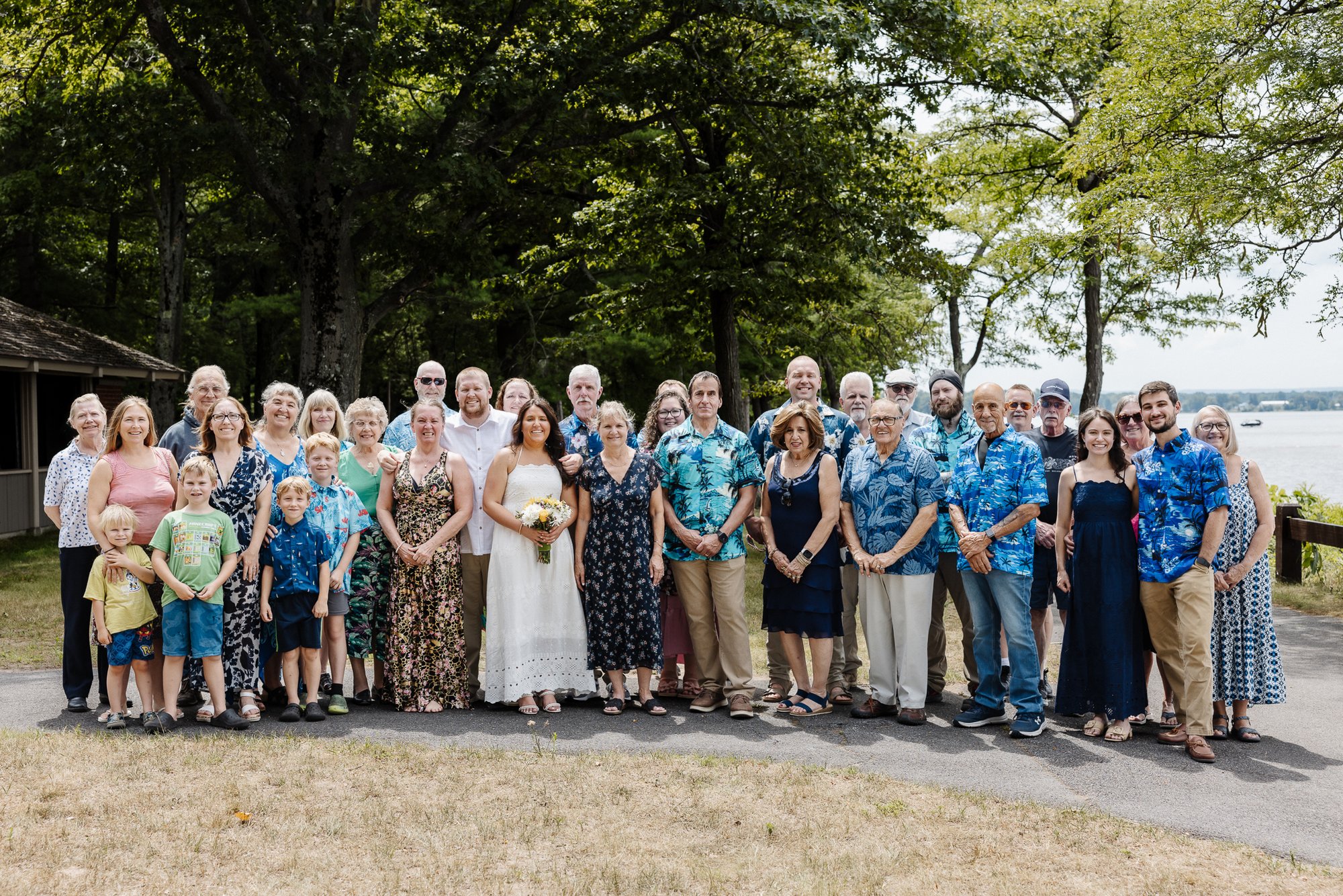 The whole family and friends gathered in one frame on the lakeside path at Verona Beach State Park, Honey and Bloom Photography